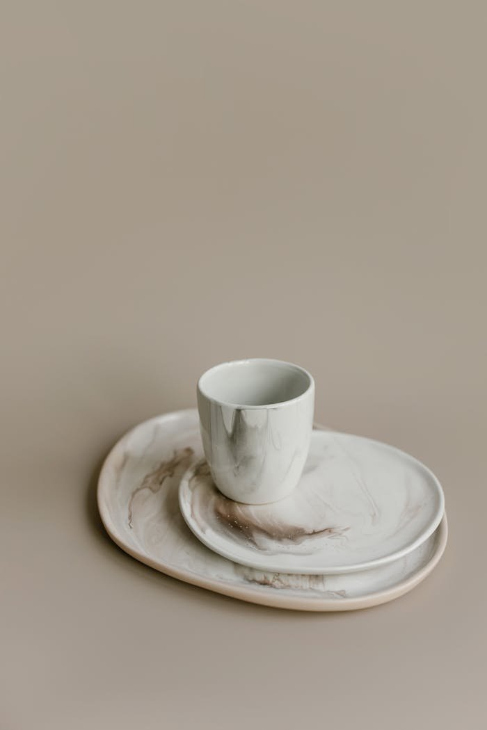 A minimalist set of marble-patterned ceramic plates and cup, ideal for modern dining aesthetics.